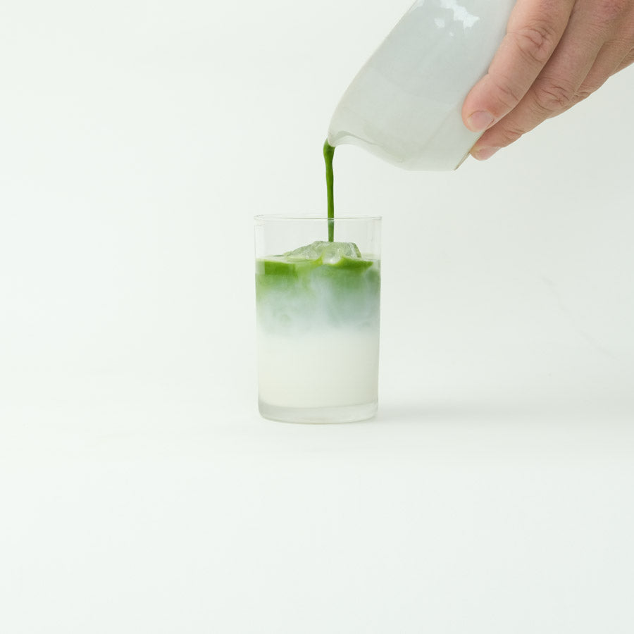 A creamy matcha latte made with Jeju Matcha, presented in a glass cup.